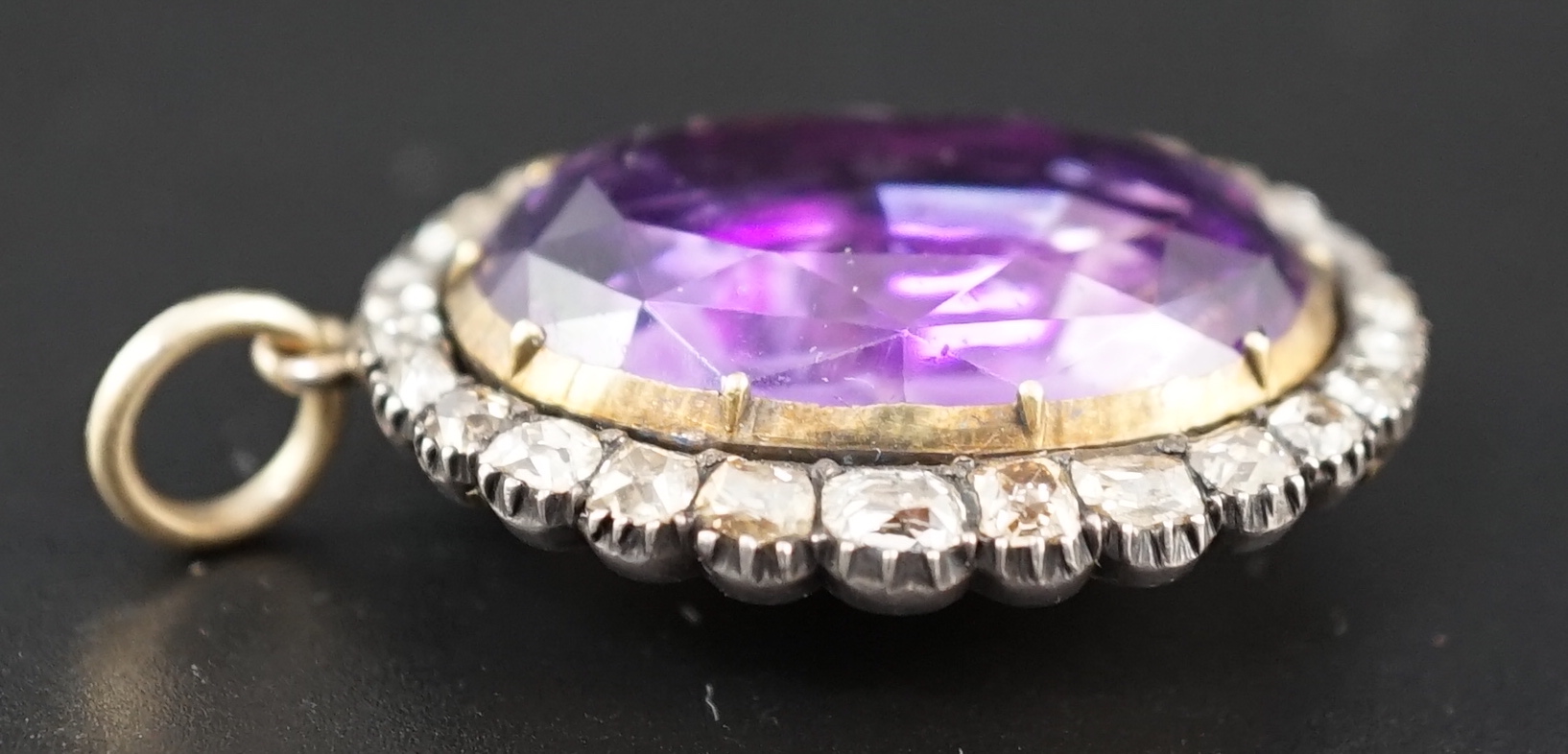 An early 19th century, gold and oval cut foil backed amethyst set pendant, with old cut diamond set border and closed back setting